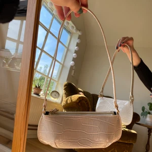 vit liten baguetteväska - en vit, mindre modell av baguetteväska med gulddetaljer och smalt band. köpt på Zalando. 