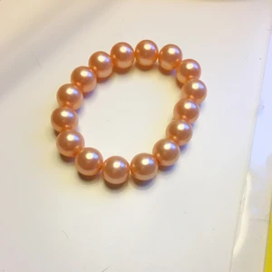 Rosa pärlarmband  - Gulligt pärlarmband. Den är i en ljusrosa färg gjord av plastpärlor. Pärlorna sitter på en plasttråd så armbandet är töjbart. Frakt ingår ej 
