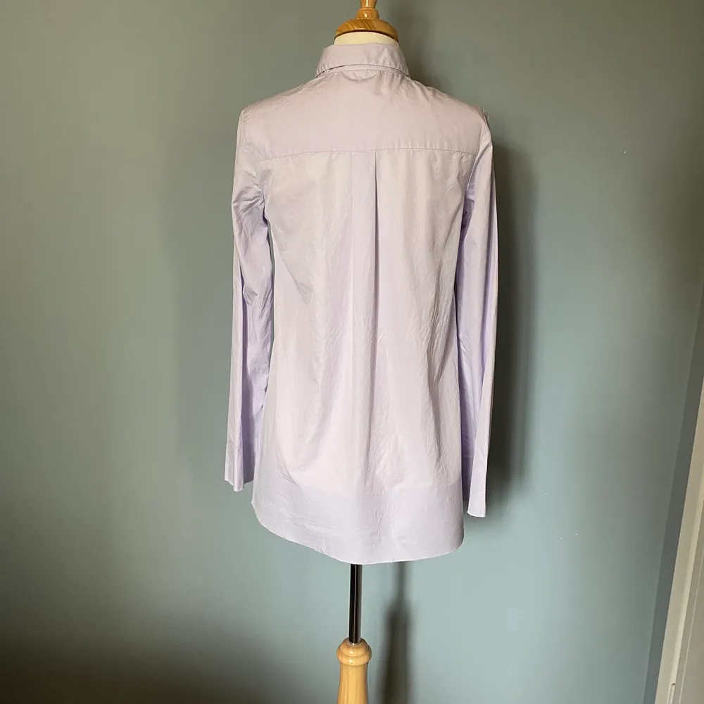 Superfin skjorta i lite längre modell i lavender från COS. Används för sällan och förtjänar ett nytt hem! Frakt inkluderat i priset! Spana gärna in mina andra annonser för samfrakt!. Skjortor.