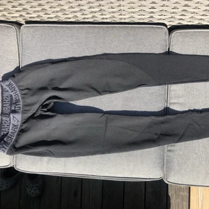 Träningsbyxor gymshark - Snygga träningsbyxor från gymshark. Ena sömnen på vänstra benet har gått upp (se 3e bilden) bör kunna fixas lätt med en enkel söm.