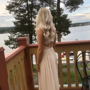 Magiskt fin långklänning - Endast använt en gång! Riktigt fin och lyxig med spets av blommor i ryggen. Färg: champagne. Nypris ca 1200kr.