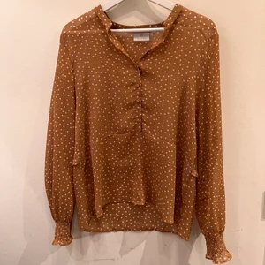 Prickig blus från KAFFE - Superfin Beige/brun blus från KAFFE med vita prickar. Tunt tyg. Storlek 34 men funkar även som 36.