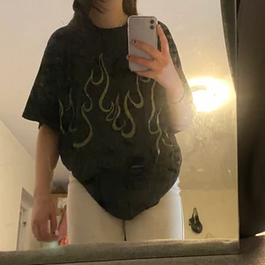 Oversized t-shirt - Svart oversized t-shirt från Shein med grönt eldtryck fram❤️‍🔥I strl M☺️ Sparsamt använd och i fint skick, 100 kr exkl frakt el bud🦋