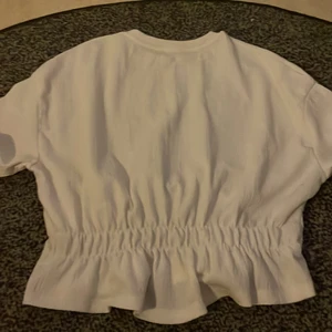 Vit blus - Jag säljer denna vita blusen som har volang där nere! Jag har använt den 3 gånger minst men annars är den i nytt skick!