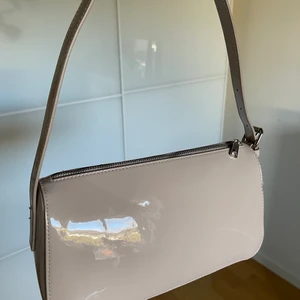 Beige axelväska - Superfin beige glansig axelväska! Praktisk storlek med ett dragkedjefack baktill. Skriv privat om ni undrar något!🌟 säljer för 100kr+frakt 