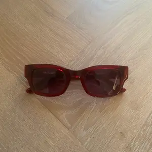 Mörkröda Solglasögon från Sunbuddies. Endast använd ett par gånger. Hög kvalité. Nypris 1400kr. 