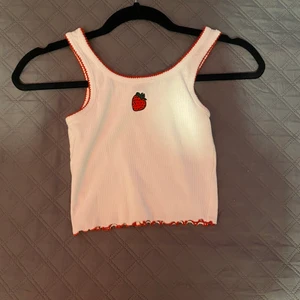 Croppat linne med jordgubbe strl xxs-m - Nu ska sälja detta gulliga croppade linne från new yorker. Har haft det i kanske 2år, men det är absolut inte slitet. Linnet är väldigt stretchig & passar därför flertal strl! Jag säljer de för att de helt enkelt inte passar min stil längre😚💗