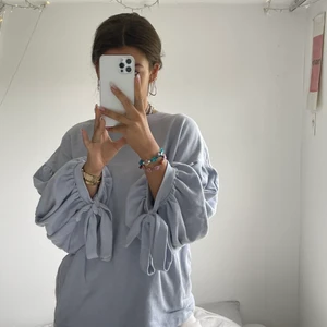 Ballongärmad sweatshirt - Baby blå mysig sweatshirt med ballongärmar. Två rosetter på ärmarna oxå. Säljer pga flytt. Sparsamt använd, frakt kommer💜 skriv om frågor!!