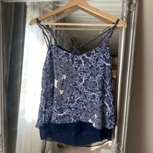 Blå blus med mönster - Blå blus med mönster och korsningar i ryggen, från kappahl i stl. Small 