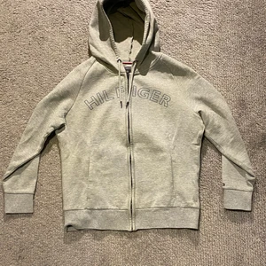 Tommy Hilfiger hoodie, grå, strl M - Passar verklig storlek (M), väldigt bra skick, knappt använd, tvättad, nypris: 799kr. Pris kan diskuteras