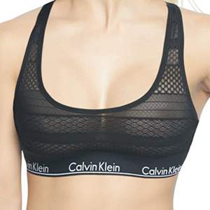 En oanvänd svart Calvin Klein bralett med lätt vadering. Den har samma see-through mönster som på första bilden i rygg och övre framdel men är opaque vid bysten. Funkar som såväl som sport bh och lättare bh/bralett.  