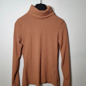 Tröja med polokrage  - Tröja med polokrage i nyttskick i storlek M. Bilderna visar den unika färgen tröjan kommer i. Inga hål eller övriga defekter. Köptes från boohoo. Mitt pris: 70kr.
