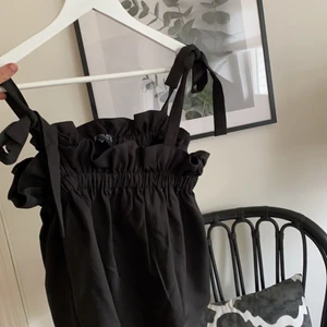 Svart topp med rosetter - Gullig svart top med rosetter som axelband, kommer från In the City men köpt på Zalando. Passar för storlek s/m💕