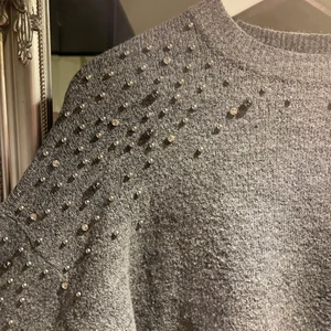 Grå stickad tröja H&M strl XS - Säljer denna fina gråa stickade tröja med strass från H&M. Superfin till en vit blus under! Jätteskön också! 