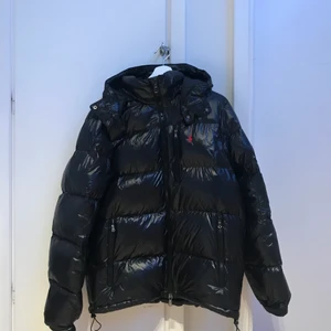 Polo Ralph Lauren Glossy Puffer Jacket - Jackan är i princip oanvänd. Den har inga skador, fläckar eller täcken på att den använts. Den är normal i storleken och sitter bra på dom som har storlek L på kläder. Original pris 4000kr