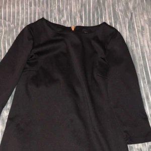 Svart trikå klänning stl S - Svart vardaglig klänning med dragkejda i guld på ryggen. Väldigt fin både till vardags och på nåt finare event 
