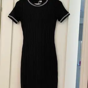 Svart klänning med vita ränder på armarna från H&M stl S, klänningen är i nyskick och går till lite ovanför knäna.                 (Säljes för 60kr +  frakt)