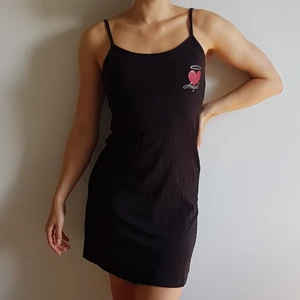 Svart nattlinne/ kort klänning med text - Svart kort klänning eller nattlinne, med ett rött hjärta vid vänstra bröstet, med texten "Angel" undertill och en gloria ovanför. Storlek S eller 34/36.