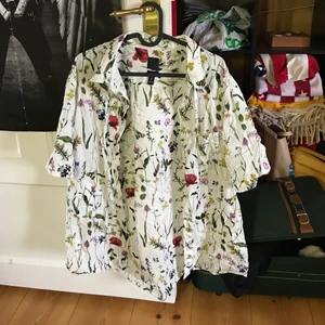 Vit Blommig Skjorta - En jättefin vit skjorta med massa olika blommor på! Hur fin som helst nu till våren/sommaren:) köpt på H&M i storlek XL. Använd ett fåtal gånger tror jag. Säljer pga att den inte används. 90kr + frakt🪴🌻