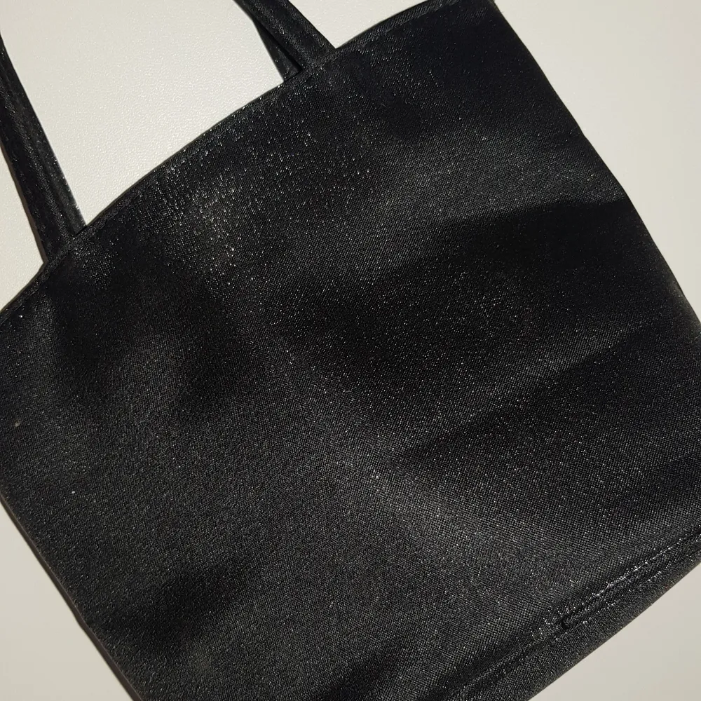 En söt liten handväska som har ett lite glitteraktigt material! Aldrig använd och är i ett fint skick🥰 Väskan har bara ett fack! Köparen står för frakten!. Väskor.