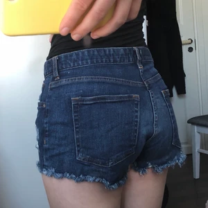 Shorts  - Mörblåa shorts med detaljer som är slitningar. Ej högmidjade 