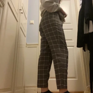 Rutiga byxor - Gråa sköna byxor med vita detaljer. Säljer då de aldrig kommer till användning. Köparen betalar frakten.