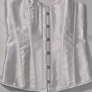 White satin corset. Overbust with lace up back. NEW without tags. Original price was 250kr.