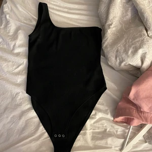 ONE SHOULDER TOP - En svart one shoulder topp från H&M, Ribbat material och skit snygg på sommaren! Sparsamt använd. (Ca 3-4 gånger)