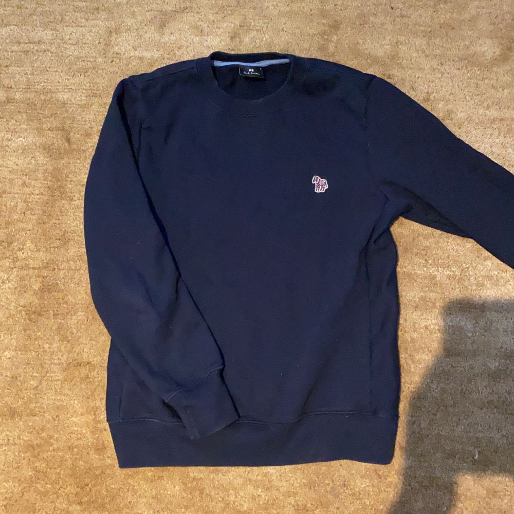 En Paul Smith tröja med en mörklblå färg. Den är i väldigt bra skick och nypriset är 1100 (från butik till butik), bilden från nätet är i samma färg och kostar 1199kr. Storleken är S och är en herr modell men fungerar givetvis för dam. Har använt den ett tiotal gånger men säljer den för att den är för liten för mig. Fritt fram att buda mina vänner! . Tröjor & Koftor.