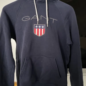 Gant Hoodie - En marinblå gant hoodie i storlek XS men funkar perfekt för en S med. Hoodien är använd max 3 gånger. Nypris ligger på 1100kr och jag säljer denna för 400kr, bud går också. Köparen står för frakt. Skriv privat för intresse :)