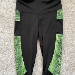 Tights  - Snygga träningstights från ASOS i bra skick, endast använda fåtal gånger. Snygga gröna detaljer på sidorna. Spårbar frakt med DHL inräknat i priset!!