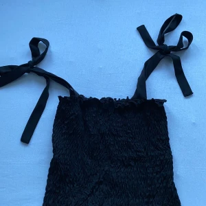 Topp - Spagetti topp med rosetter på axlarna storlek m men passar även för s