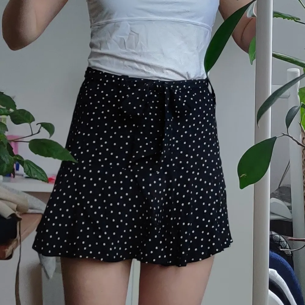 Prickiga bermuda shorts med skärp och volang från Zara. Storlek M, passar för midjemått upp till 2*38cm pga skärpet. De är som en kjol med inneshorts -> så en go to om man ska ut och vill visa benen utan att oroa sig för att flasha, cykla eller gå i blåst Egenskaper och detaljer: tunn kjol, svart och vit prickig, skärp, sidodragkedja, ej genomskinliga Märke: Zara (Basic) Material/komposition: 100% viskos Skick: i bra skick, sparsamt använda. Kjolar.