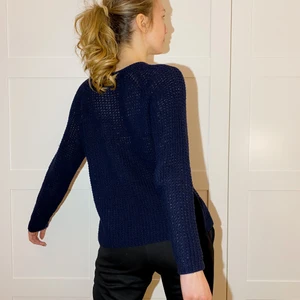 Stickad tröja - marinblå - S - En tätstickad marinblå tröja i storlek S från märket Soaked in Luxery. Plagget är ej figursytt men lägger sig inte heller pösigt då den har en rak figur. Vid fotningen av plagget användes blixt vilket får den att se mer genomskinlig ut än vad tröjan egentligen är. 
