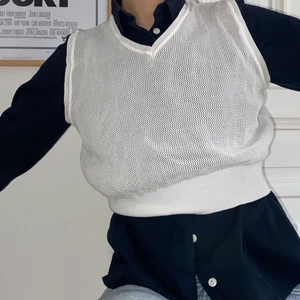 Vit fisknäts-väst (cropped) - Vit väst i fisknätsmaterial och croppad modell. Sitter fint över stora skjortor eller tighta toppar. Storlek s. Priset är exklusive frakten. 