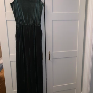 Byxdress strl 36 - Supersnygg byxdress som ny i snygg skimrande grönt som sammetsliknande tyg. För stor för mig. 143 från axelband och ner till benslut. Innerbenslängd 74 cm. Endast använd 1 ggr. Skickar gärna med postens skicka lätt som är spårbart.