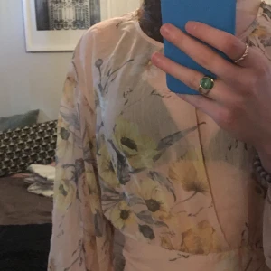 Blommig blus - Blommig blus från H&M med öppen rygg. Aldrig använd, säljer pga inte min smak. Den är ganska genomskinlig med snörning i ryggen så man kan knyta rosett båda fram och bak.
