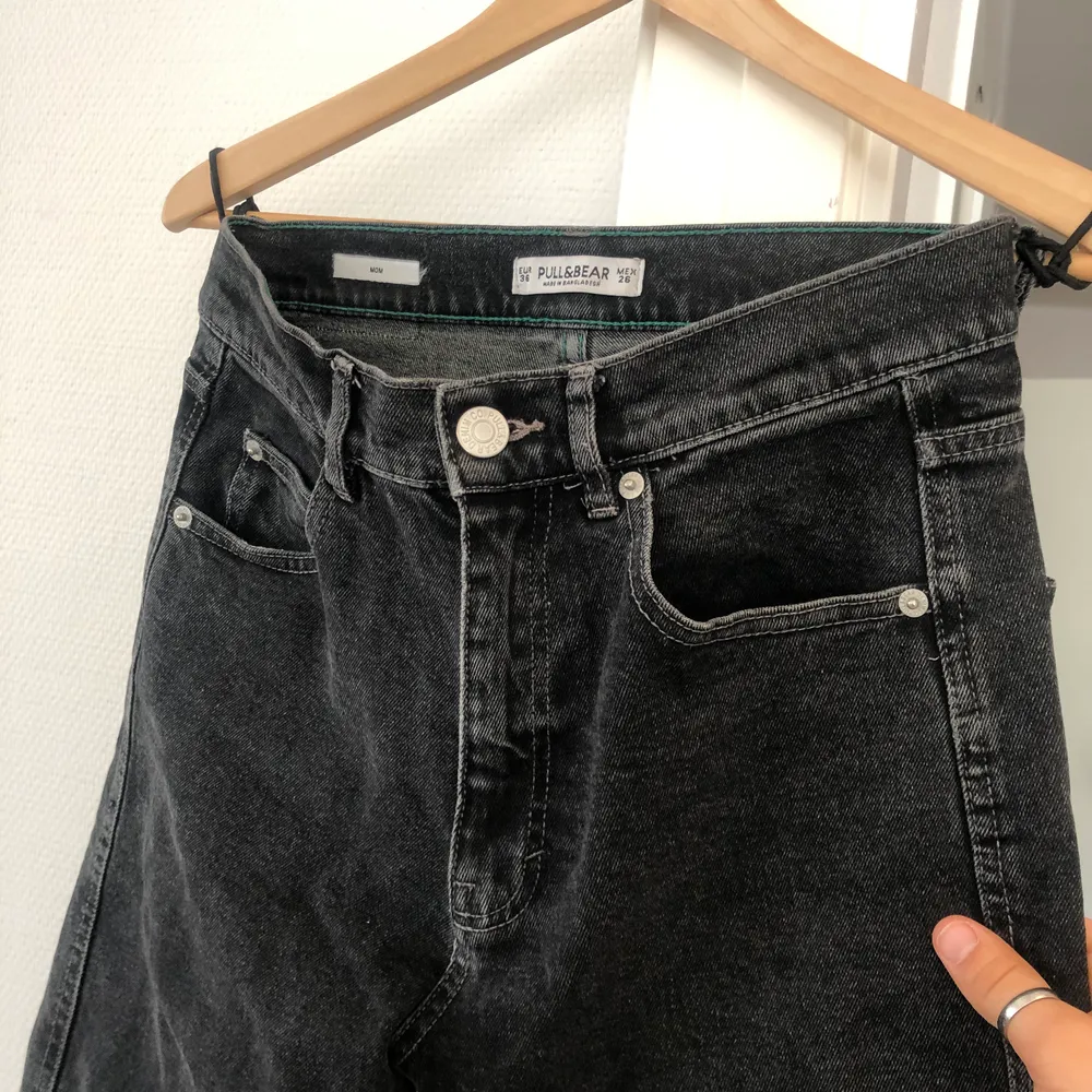 Fina mom-jeans från Pull&bear i vintagetvätt. Färgerna är svart/grå med avklippta byxben nedtill. Storlek 36. I mycket fint skick. . Jeans & Byxor.