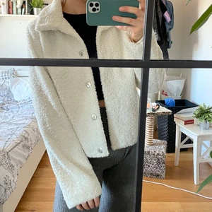 Vit Teddy jacka - Vit Teddy jacka från Nelly använd 2-3 gånger. Storlek 34 (jag är mer en 36:aså kommer sitta lite mer oversize på en 34:a). Fodrad på insidan så varm nog för tidig vår/sen höst. Priset är exl frakten som ligger på 66kr och är spårbar :)