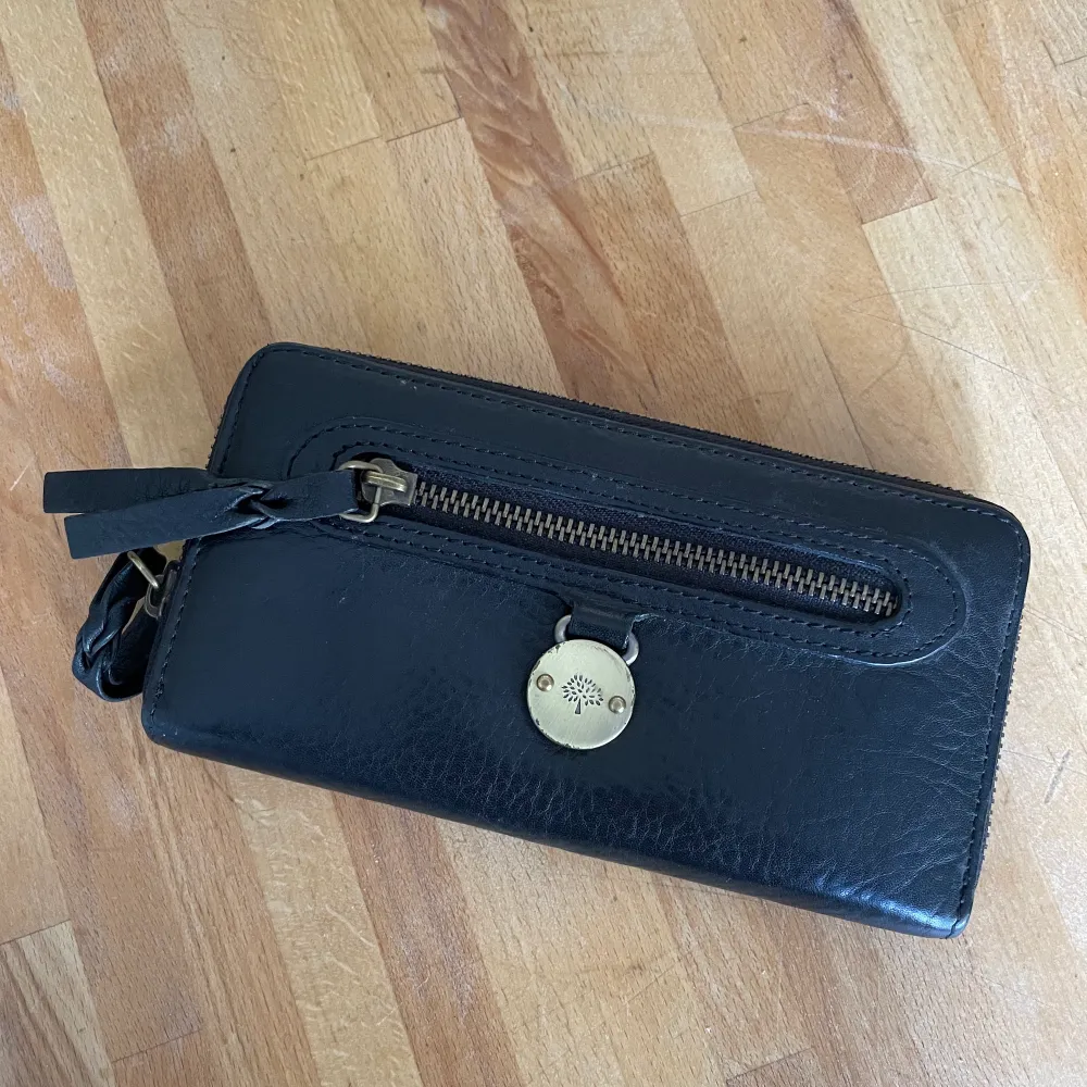 Svart Mulberry plånbok i svart skinn (snygg kopia) säljes i Tyresö. Tyvärr har Mulberry märket blivit lite skavt, därför säljer jag den billigt.. Accessoarer.