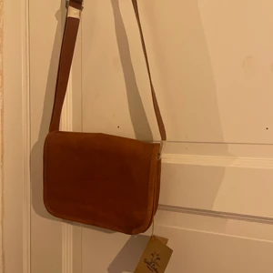 Brun skinnväska - Supersöt, exklusiv brun axelremsväska, lagom stor med många fack!! Helt oanvänd.