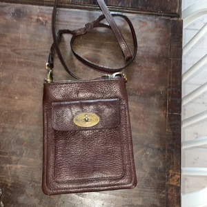 Mörkbrun väska - 21x16,5 cm. Äkta skinn. Köpt i Thailand. Långt axelband. Mörkbrun. Samfraktar gärna med övriga annonser 