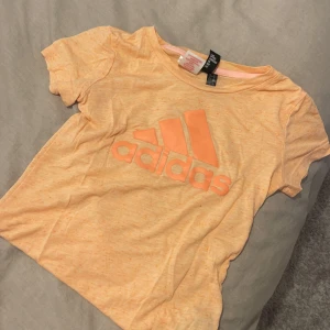 Adidas t-shirt - Använd endast en gång! Tshirten är i barnstorlek 11-12y men har passat på mig och då suttit som en xxs. Färgen gör sig inte rättvis på bild, den är mer rosa/peach! 💕