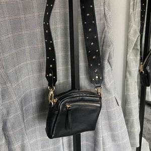 Svart väska  - Svart väska med ett brett band med svarta prickar. Mindre väska men väldigt snygg!