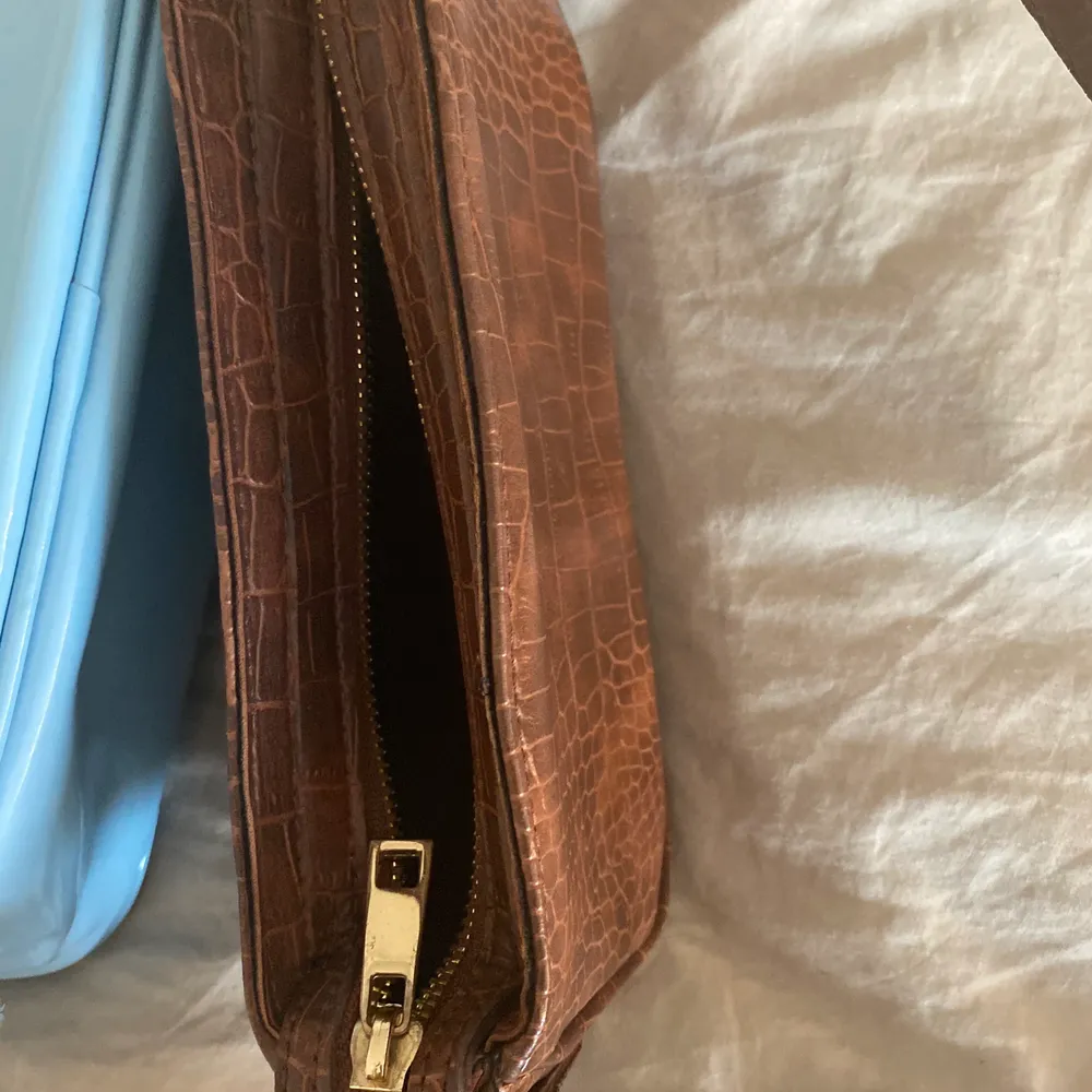 En liten brun väska. Väskor.