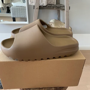 Yeezy slides (core) - Säljer mina yeezy slides färgen core ( bruna ) pga att dom är för små. Strlk 44,5 ( obs små i strlk ). Helt DS aka oandvända. Köpta för 1875kr. Säljes för 1600kr.