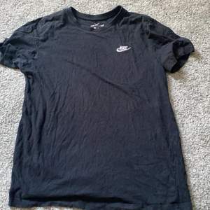 En svart Nike t-shirt , har ett litet hål vid armen men det kan man du igen och det syns knappt