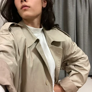 Oversized Trenchcoat - En klassisk beige trenchcoat kappa som aldrig går ur tiden. Är i så gott som nytt skick. Inga fläckar eller skador alls. Inköptes på Stadsmissionen men säljes då den ej kommer till användning. Från märket Gulins enligt ettiketten som det även står ”kemtvätt” på så antar att det är ett fint märke. Det står ingen storlek i den men den är stor och jag har använt den som en oversized kappa men den lär passa alla. Olika mycket oversized bara. Är 170 lång och en S i storlek. På mig går den till vaden.