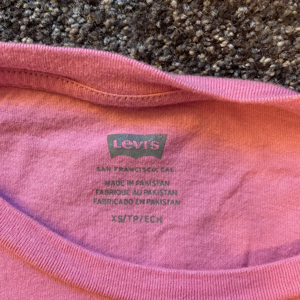 Säljer min rosa Levis T-shirt med rött tryck. Jättefin kvalite och skönt material, nästan aldrig använt. Storlek XS och den kostar 100kr. T-shirts.