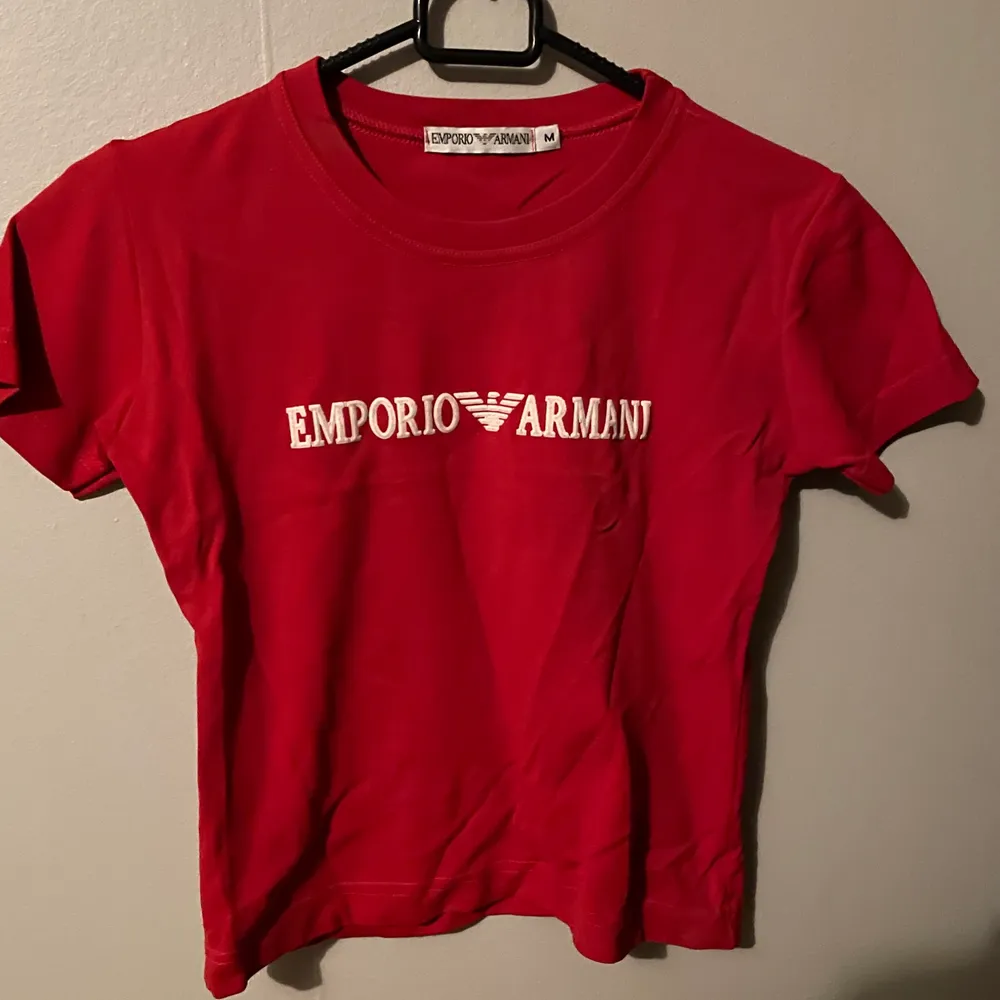 Säljer en röd Emporio Armani T-Shirt. Knappt använd så i jättebra skick. Den är äkta. Lägg gärna bud på den men börjar med 200kr då den nästan är i nyskick. T-shirts.